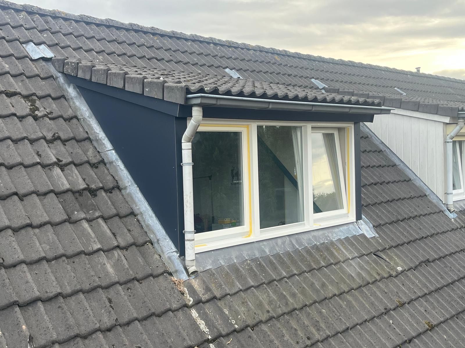 Dakkapel met nieuwe witte kozijnen en antraciet zijwangen, de tape zit er nog op