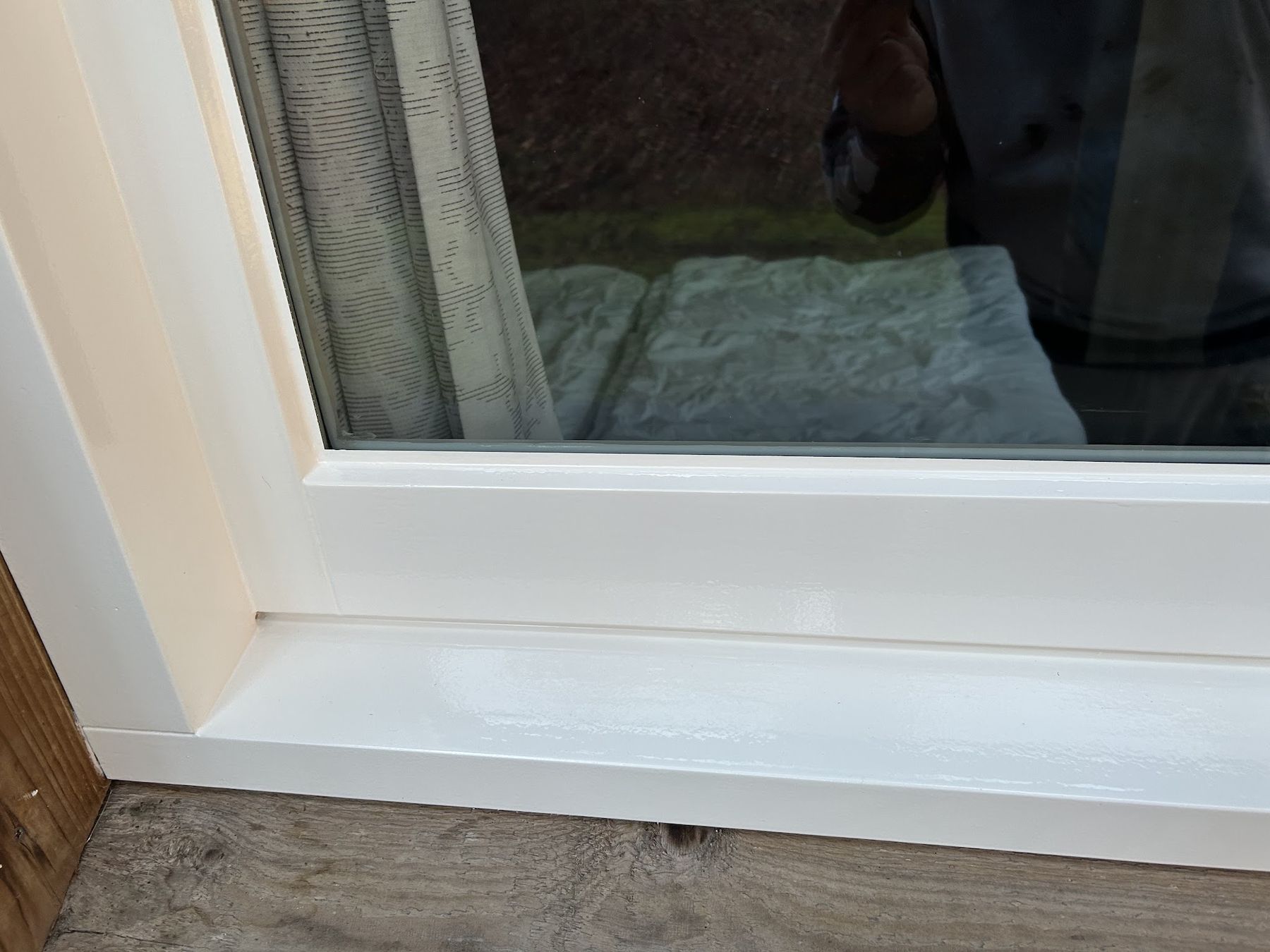 Close-up van een vers gelakt crèmekleurig kozijn met een strakke glanzende afwerking